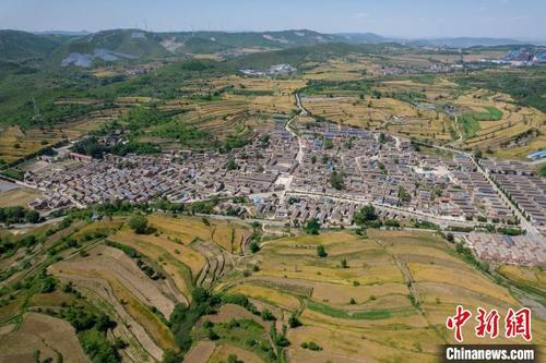 中国侨网中国传统古村落冶底村被金黄色的梯田包围,十分壮观。 韦亮 摄