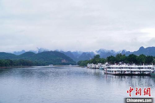 中国侨网烟雨中,漓江之畔的群山如同被一层轻纱笼罩。陈冠言 摄